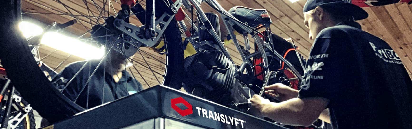 Man repairing speedway bike on scissor lift table